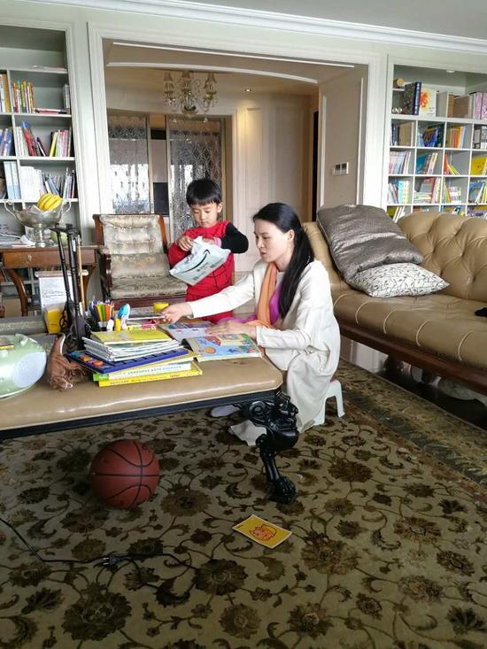 朱小貞和小兒子在客廳里,背后書架為起火點。受訪者供圖